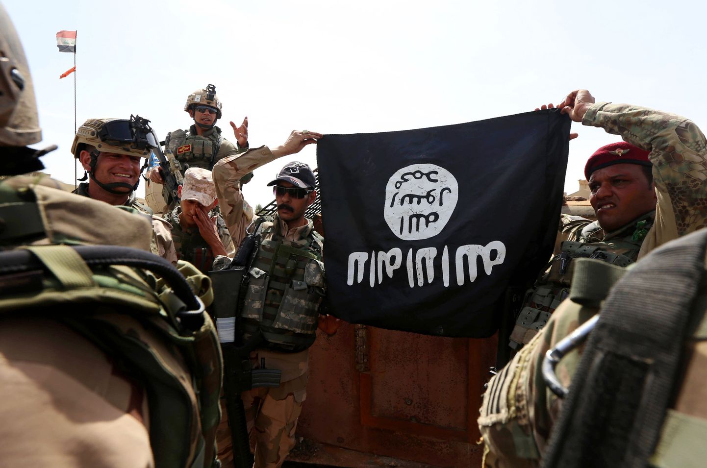 Iraagi sõdurid poseerivad konfiskeeritud Islamiriigi lipuga