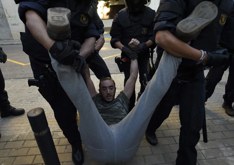 Kataloonia Mossos D'Esquadra korrakaitsjad üle käte läinud meeleavaldajaga. Foto: LLUIS GENE / AFP / Scanpix