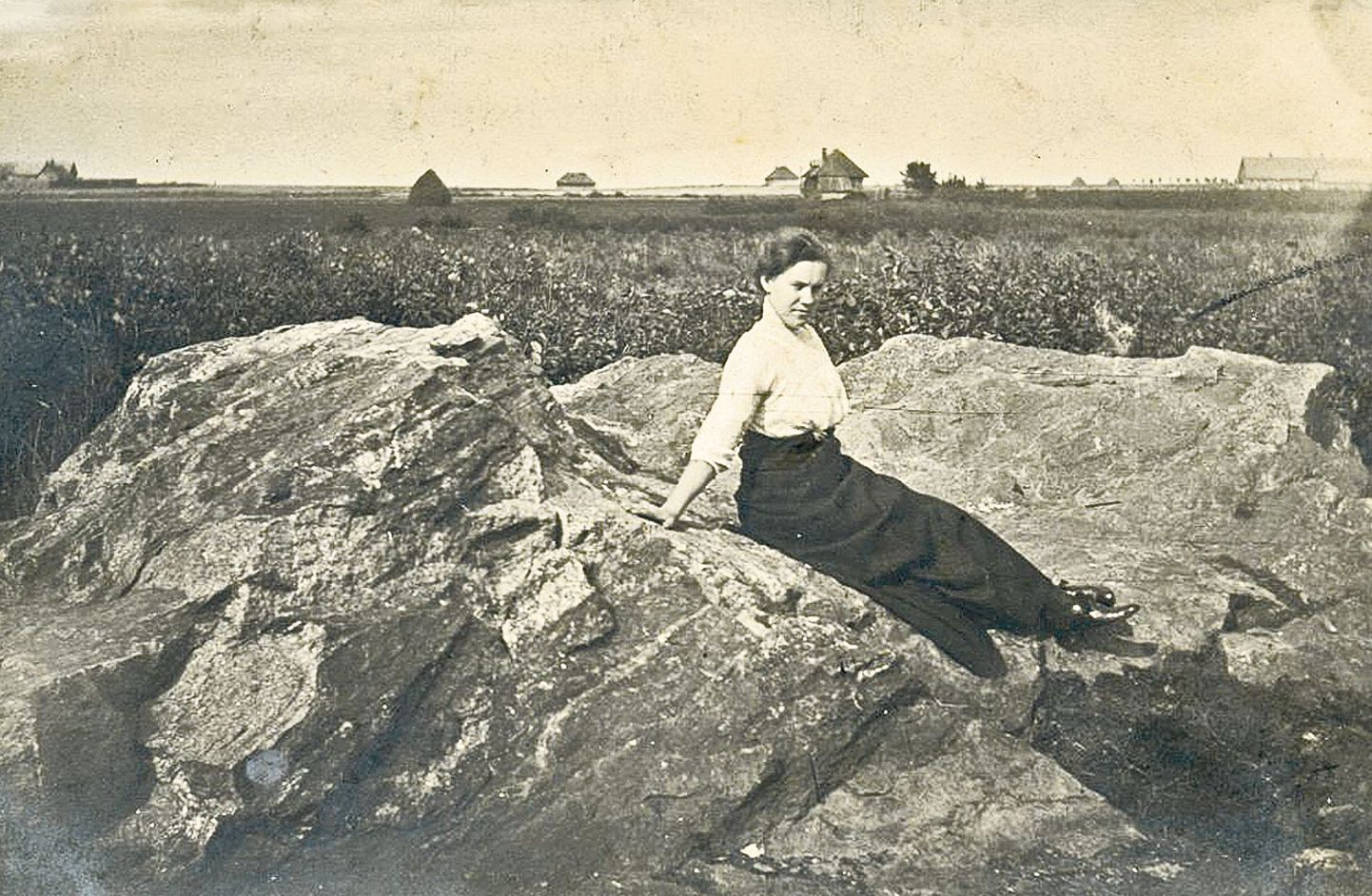 Anne luhal suurel kivil istub Lydia Naarits-Raud, 1913, seisab foto taga. Kahjuks pole kirjutaja teinud märkmeid, mis hooned jäid ilusa noore naise ja ilusa suure kivi taha.