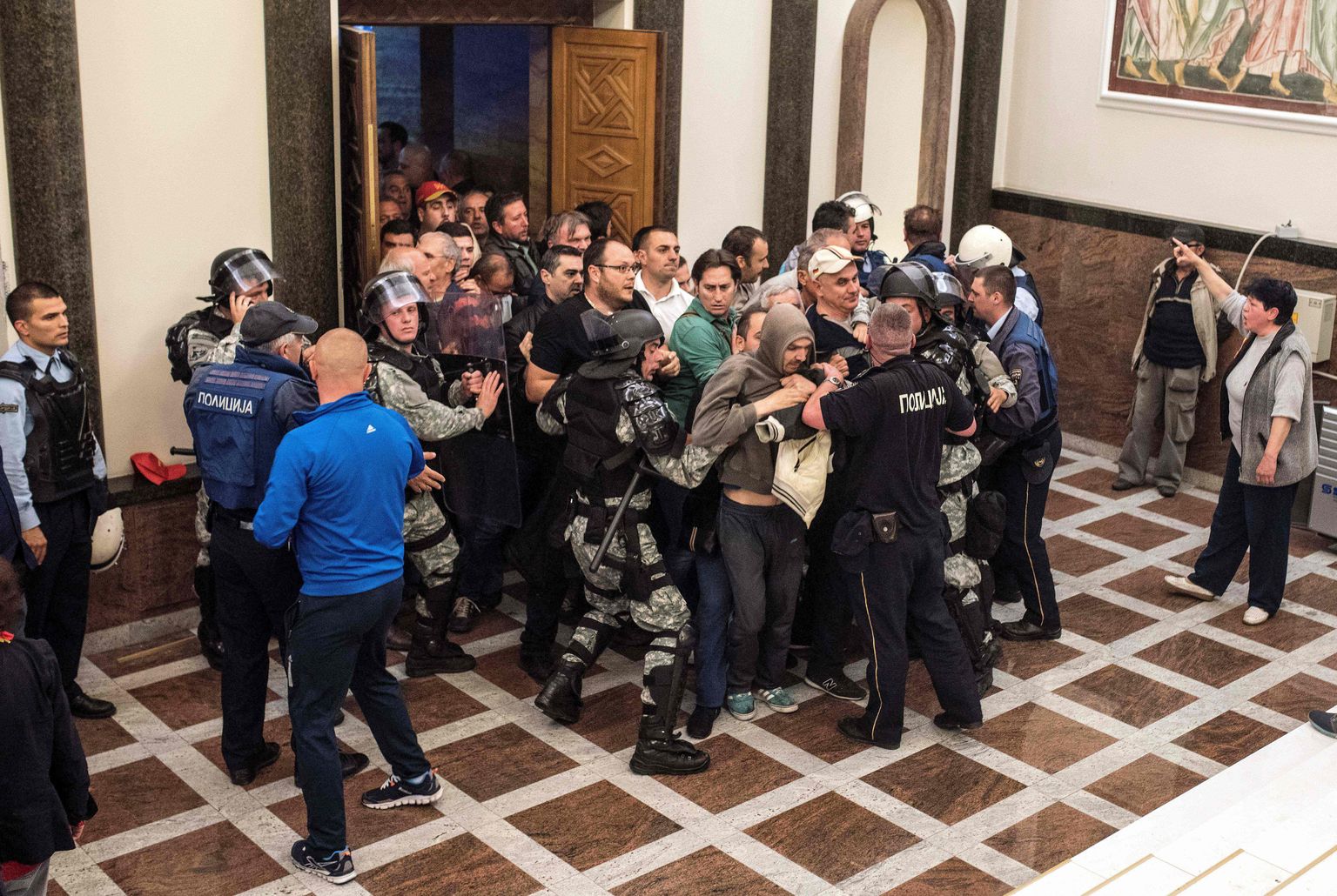 TOPSHOT - Policemen try to contain protesters trying to enter Macedonia's parliament to protest against against what they said was an unfair vote to elect a parliamentary speaker, following months of political deadlock in the Balkan country in Skopje on April 27, 2017. / AFP PHOTO / Robert ATANASOVSKI