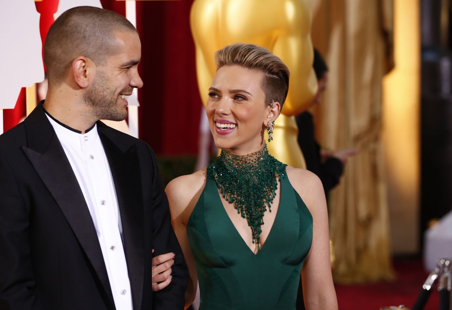Actress Scarlett Johansson wears a Versace dress as she and her husband Romain Dauriac arrive at the 87th Academy Awards in Hollywood, California February 22, 2015.   REUTERS/Lucas Jackson (UNITED STATES TAGS:ENTERTAINMENT) (OSCARS-ARRIVALS)