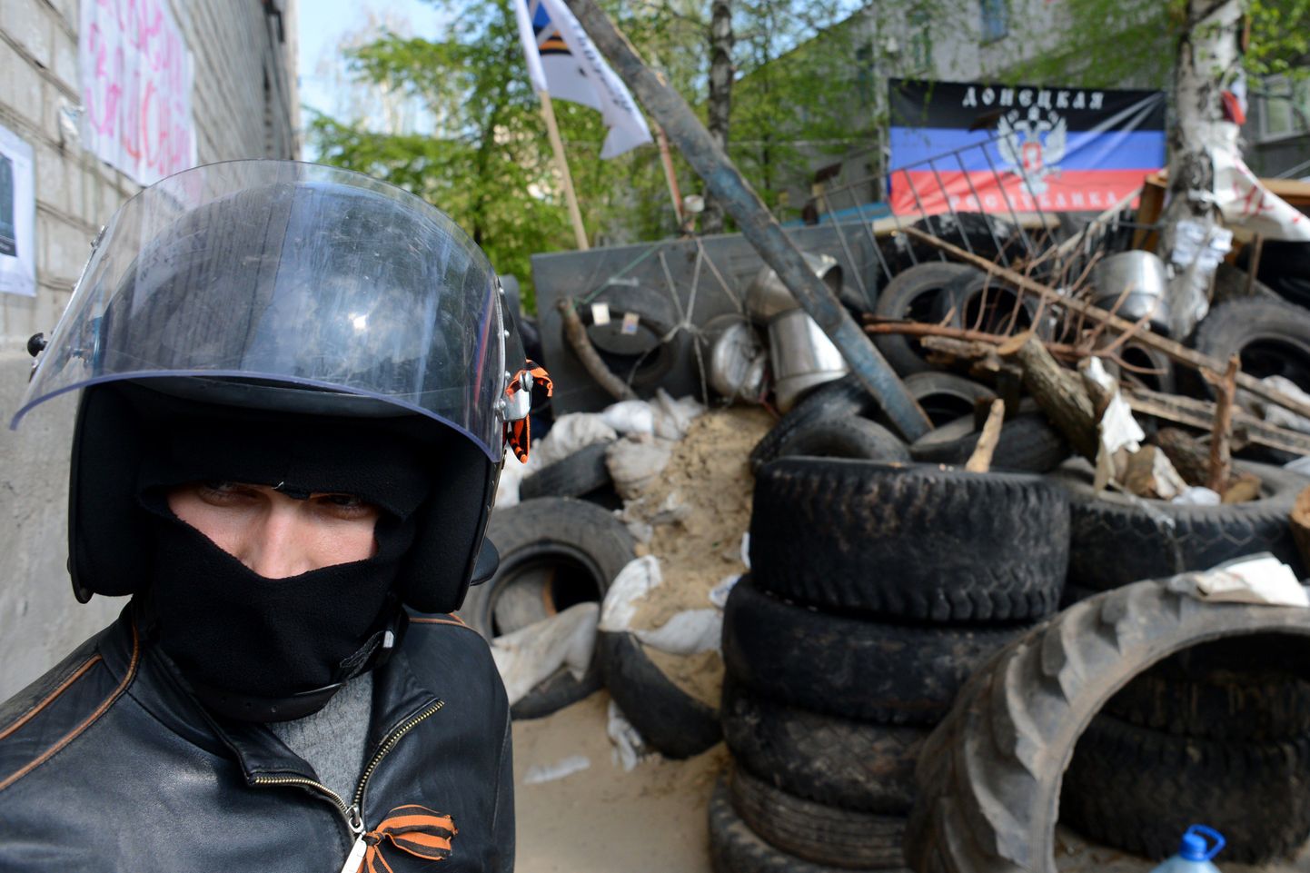 Maskiga venemeelne aktivist barrikaadi ja nn Donetski rahvavabariigi lipu juures Slovjanskis.