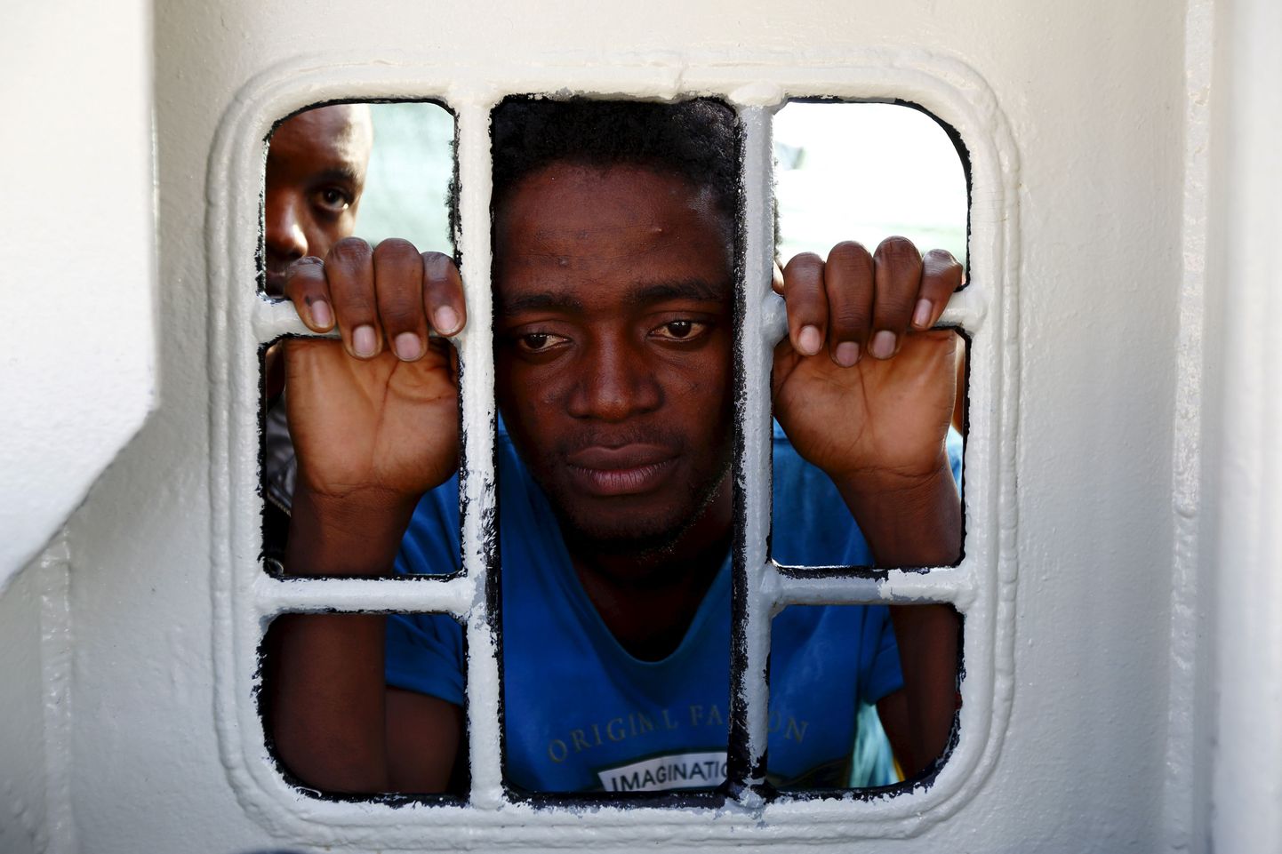 Migrant vaatamas päästelaeva Bourbon Argos aknast välja, samal ajal kui alus jõuab Trapani saare sadamasse. Sitsiilia, Itaalia