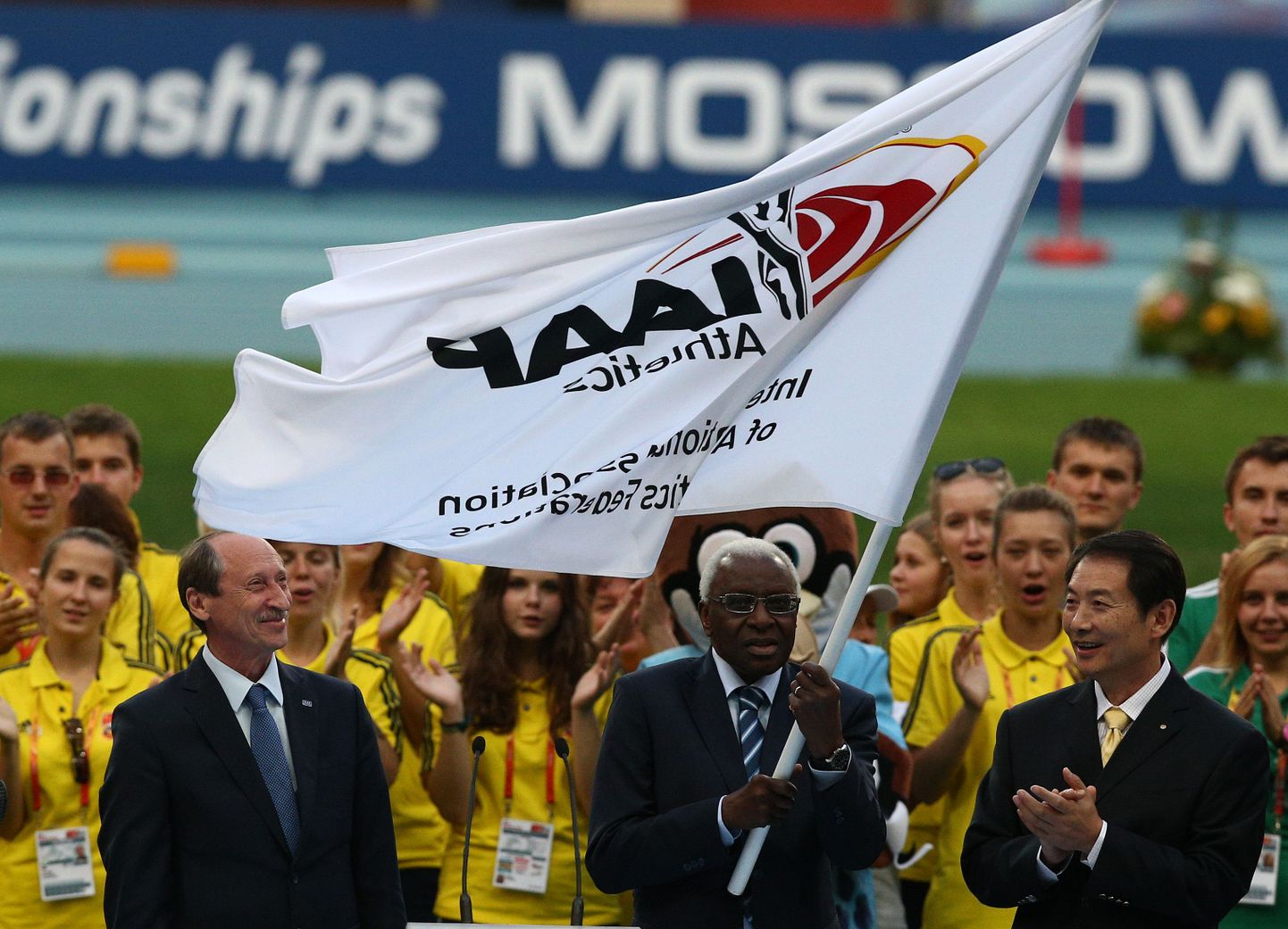 2013. aastal Moskvas:
Vasakult: tänaseks IAAFi laekuri kohalt tagasi astunud Venemaa kergejõustikuliidu president Valentin Balahhintšev, IAAFi lippu lehvitav IAAFi endine president Lamine Diack ning Hiina delegatsiooni esindaja.
