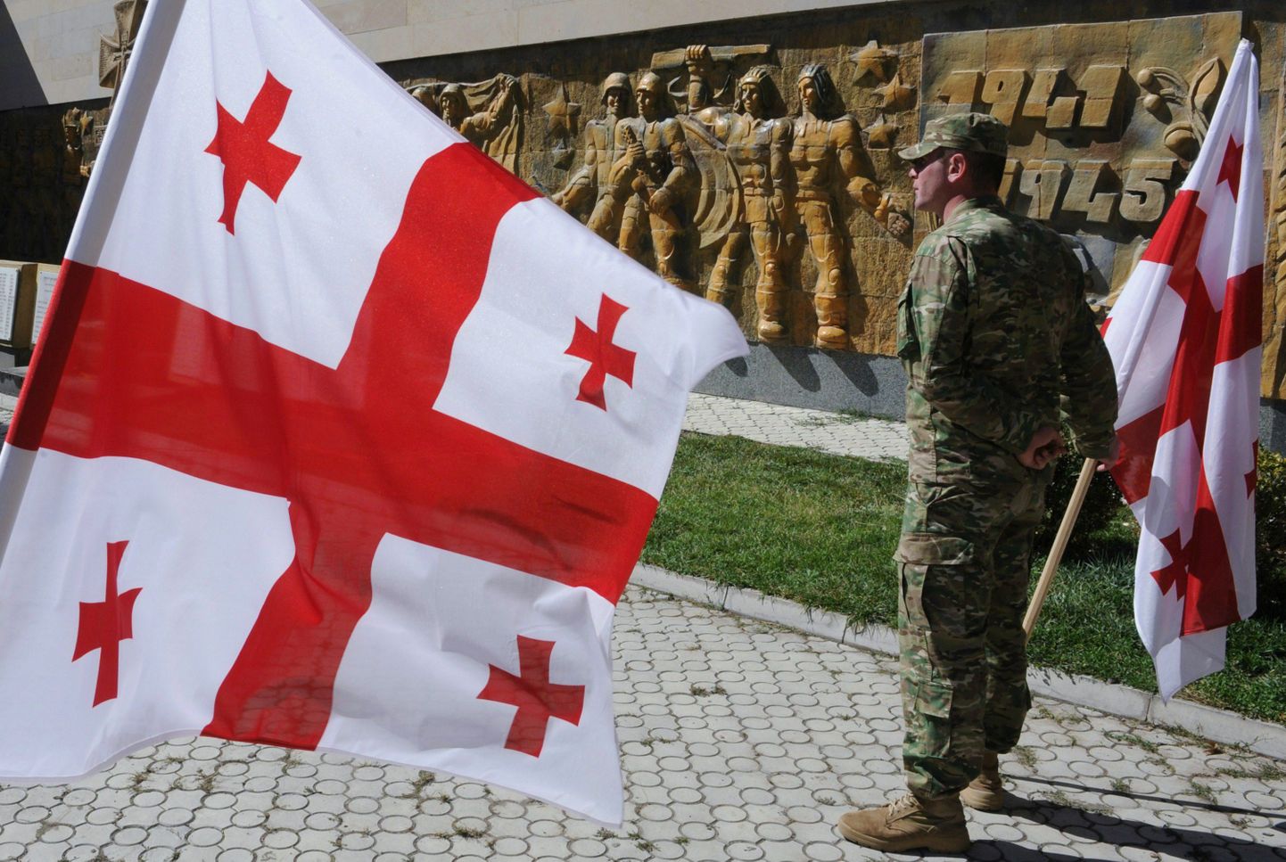 Gruusia sõdur riigilippudega.