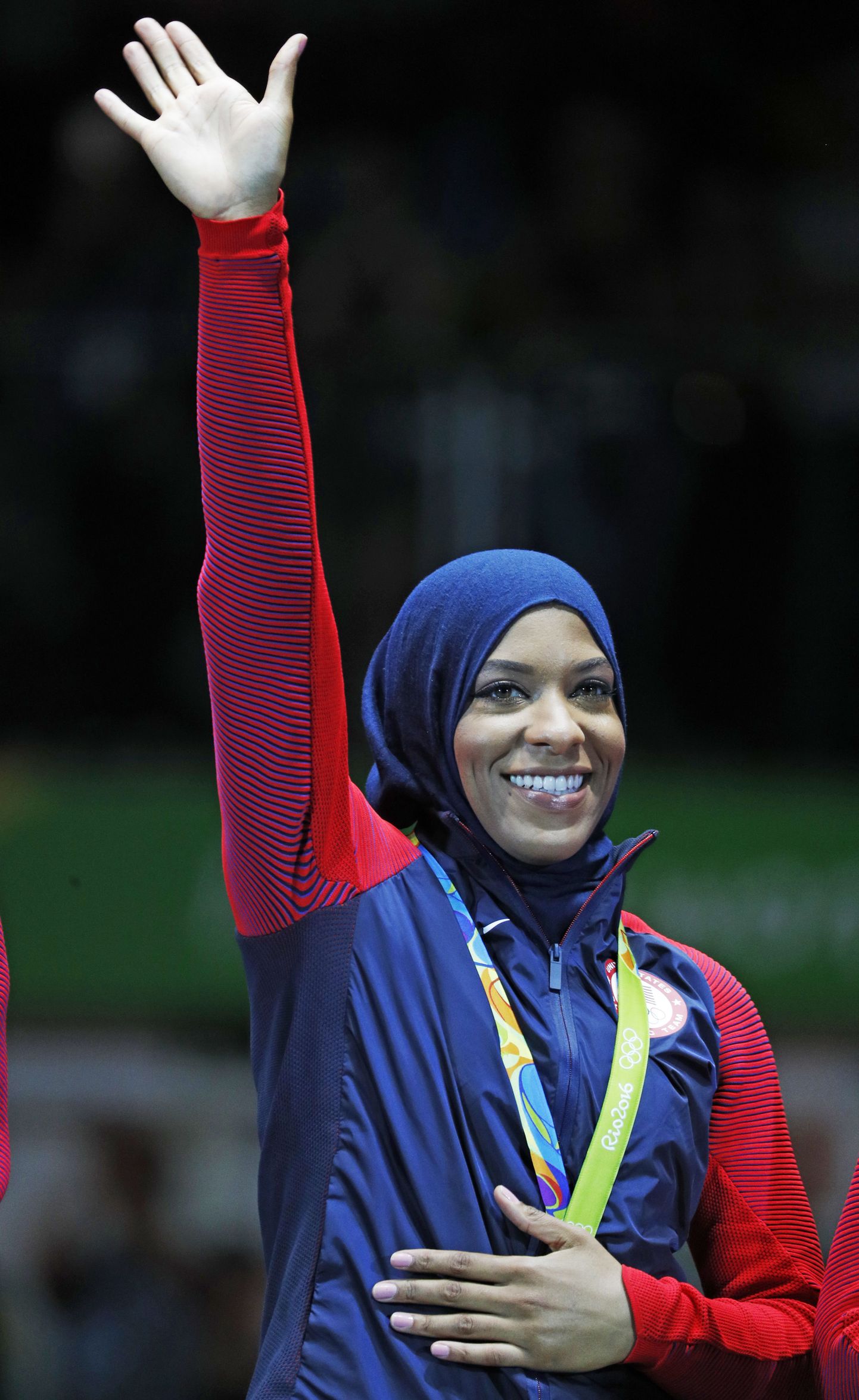 Ibtihaj Muhammad of the United States pose with her bronze medals on the podium after the womens team sabre fencing event at the 2016 Summer Olympics in Rio de Janeiro, Brazil, Saturday, Aug. 13, 2016. (AP Photo/Vincent Thian)