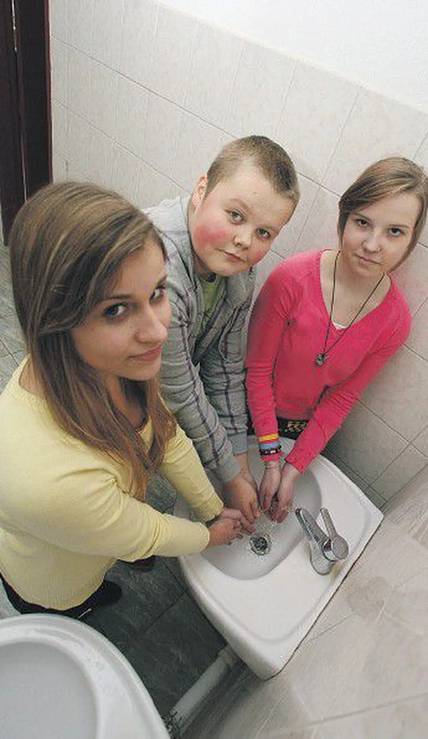 Ученики 7-го класса Пяэскюлаской гимназии Сеэлика Соллберг, Лийна Микуметс и Маркус Микк знают, как нужно правильно чихать и мыть руки.