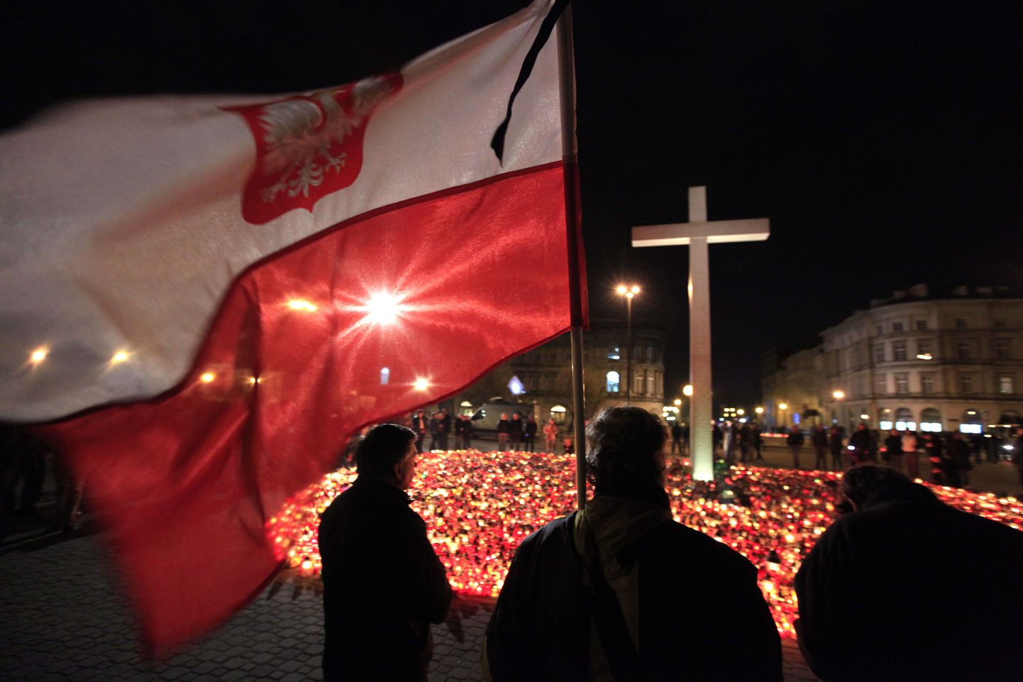 Poola leinajad lipuga pühapäeva õhtul presidendilossi ees.
