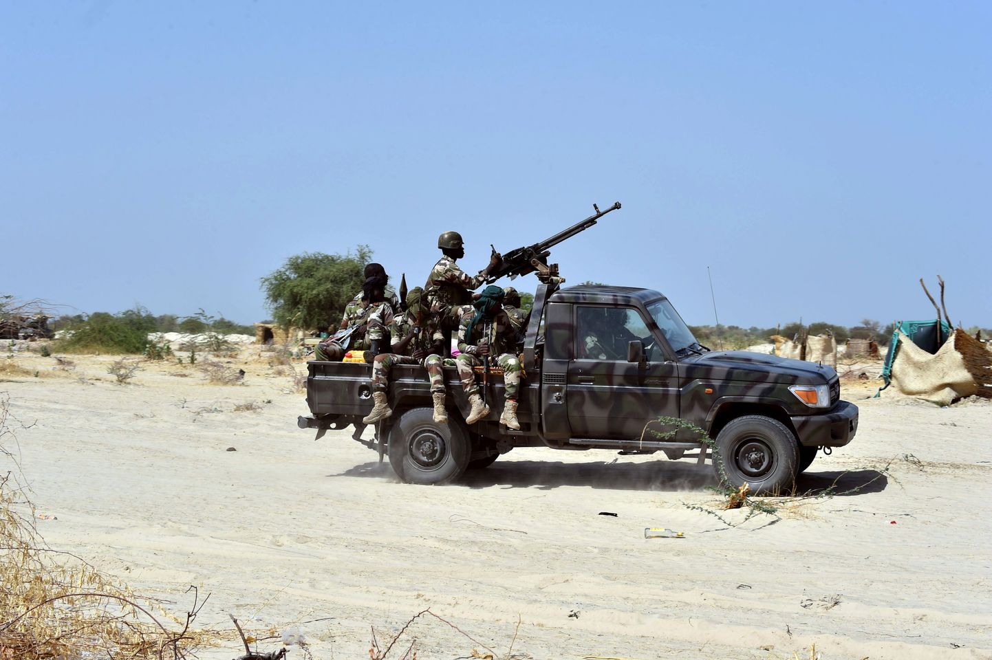 Niger soldiers ride in a military vehicle on May 25, 2015 in Malam Fatori, in northern Nigeria, near the border with Niger, where the Niger and Chadian army troops are working together in support of Nigerian forces, to fight the Boko Haram Islamist group. Boko Haram, which wants to create a hardline Islamic state in northeast Nigeria, has been pushed out of captured towns including Malam Fatori, and territory, since February by Nigerian troops with assistance from Niger, Chad and Cameroon. AFP PHOTO / ISSOUF SANOGO