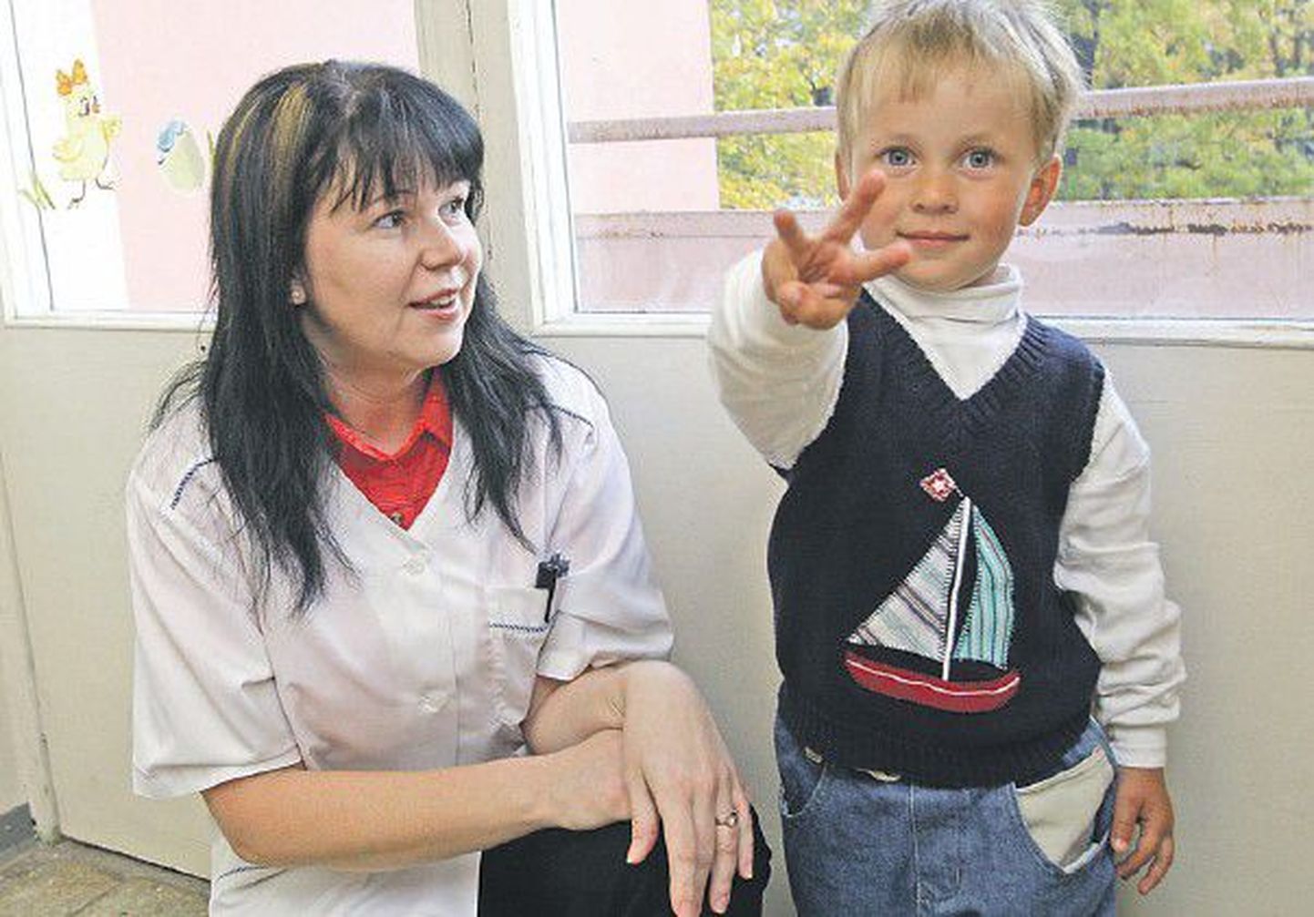 Маленький житель Тарту Роомет Тапфер показывает свой возраст на трех пальцах. Медсестра клиники Тартуского университета Арле Хурбола в ближайшие месяцы должна привлечь к проекту еще 2000 таких же готовых к сотрудничеству детей.