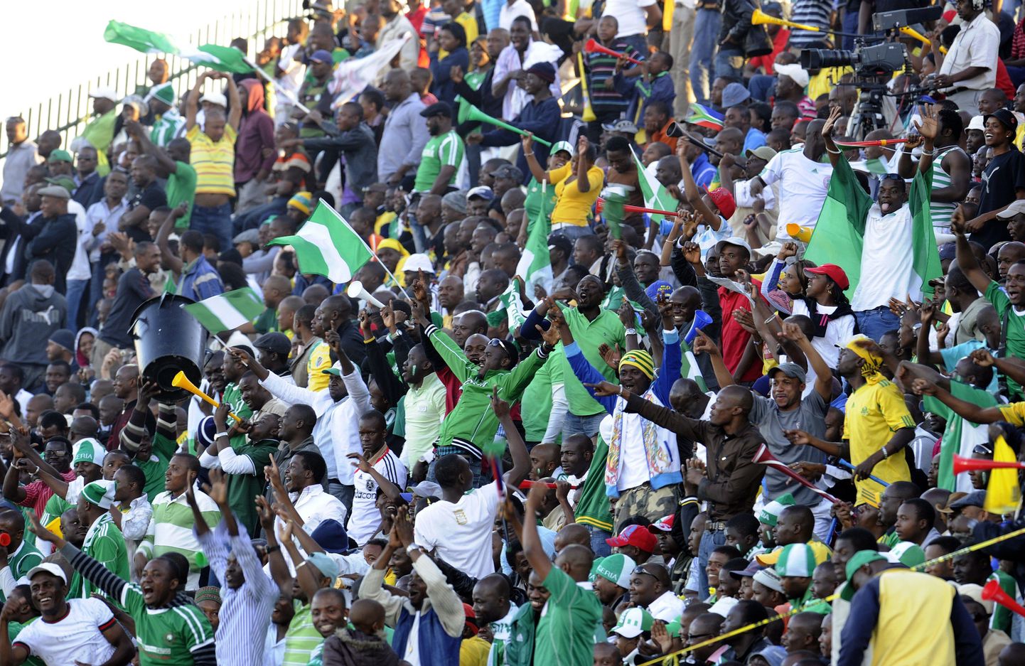 Нигерийские болельщики на стадионе поддерживают свою команду в матче против КНДР.