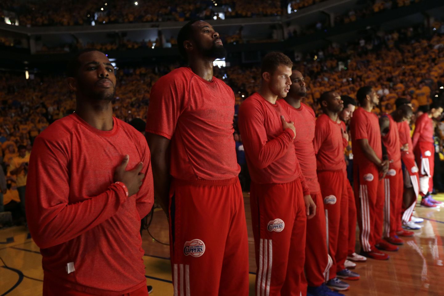 Members of the Los Angeles Clippers listen to the national anthem before Game 4 of an opening-round NBA basketball playoff series against the Golden State Warriors on Sunday, April 27, 2014, in Oakland, Calif. The Clippers chose not to speak publicly about owner Donald Sterling. Instead, they made a silent protest. The players wore their red Clippers' shirts inside out to hide the team's logo. (AP Photo/Marcio Jose Sanchez) / TT / kod 436