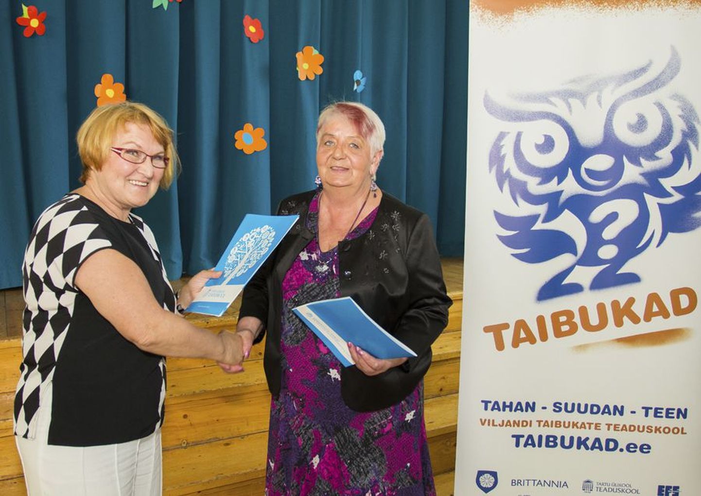 Fotomeenutus 2014. aastast, mil Taibukate teaduskooli avamisel pani selle tegevjuht Lilian Tambek (paremal) koos Tartu ülikooli teaduskooli direktori Viire Sepaga käe alla ühiste huvide protokollile.