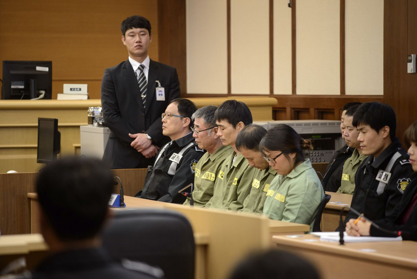 Sewoli kapten Lee Joon-seok (rohelistes riietes ja prillidega) koos meeskonnakaaslastega kohtusaalis.