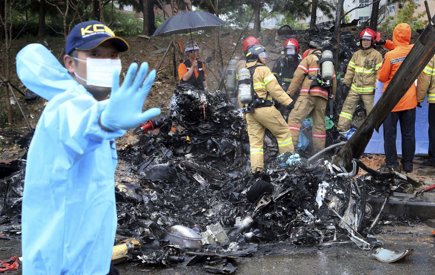 Firefighters inspect the wreckage of a helicopter which crashed near an apartment complex and school in Gwangju, South Korea, Thursday, July 17, 2014. The firefighting helicopter crashed Thursday, killing two people, officials said. (AP Photo/Yonhap, Park Chul-hong) KOREA OUT / TT / kod 436