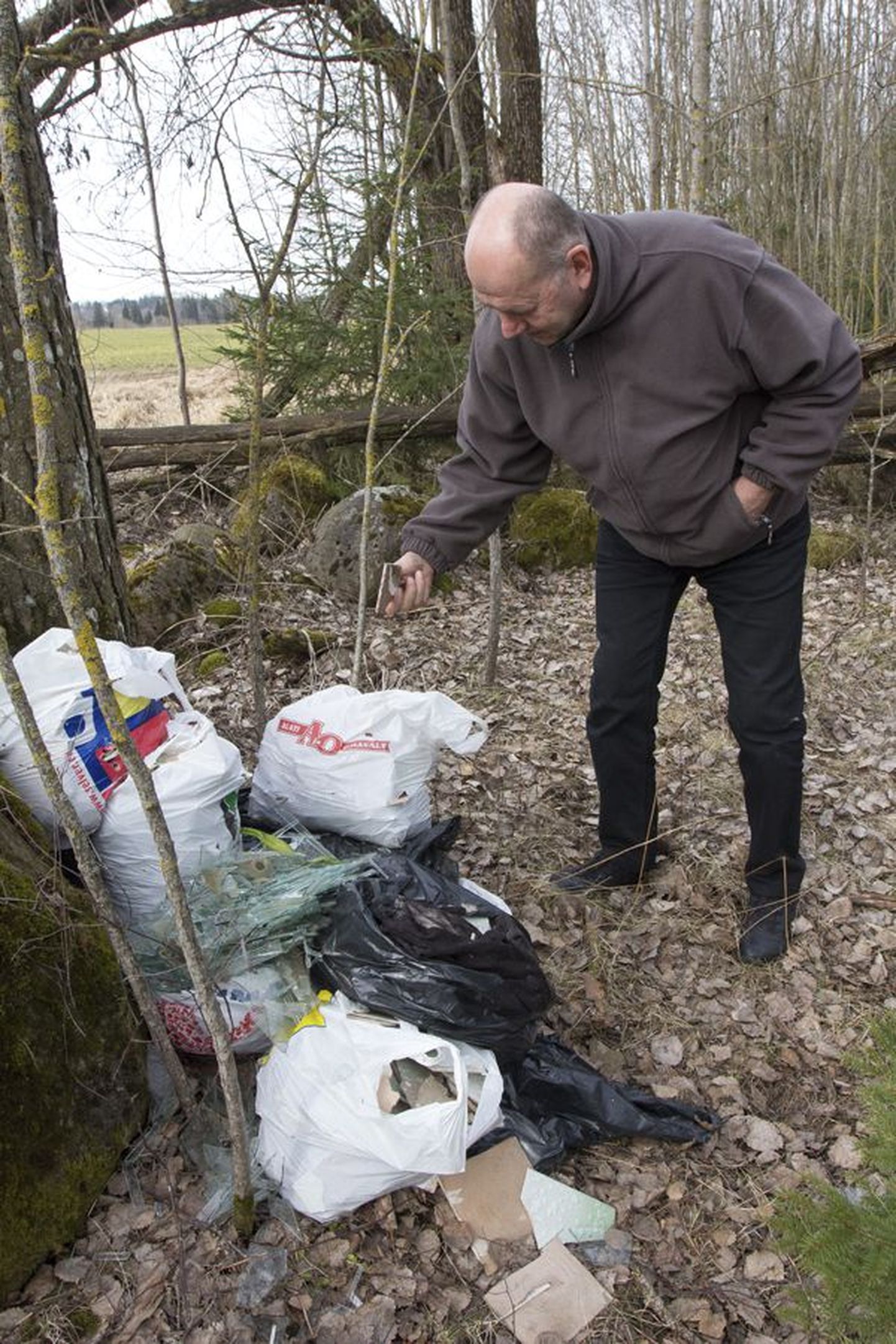 Viljandi valla keskkonnaspetsialist Kalle Aavik äsja leitud ehitusjäätmetega, mis olid väikestes kottides jäetud ühele Sammuli kinnistule.