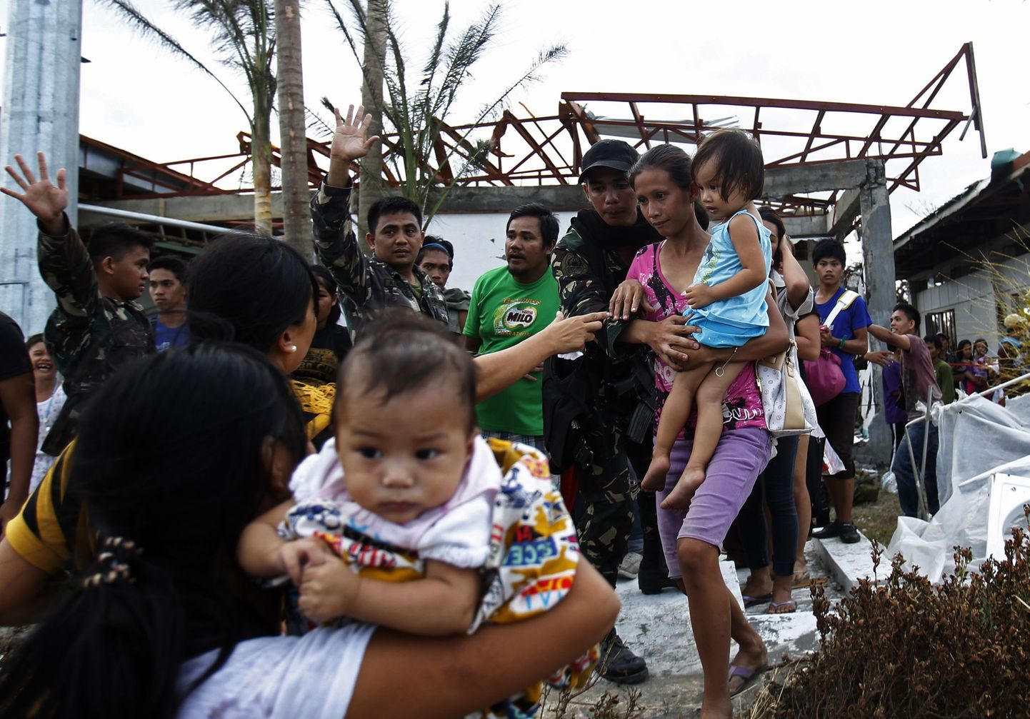 Sõdurid aitavad taifuuni tõttu kõvasti kannatada saanud Taclobani linna elanikke USA sõjaväelennukile, mis viib inimesed Manilasse.