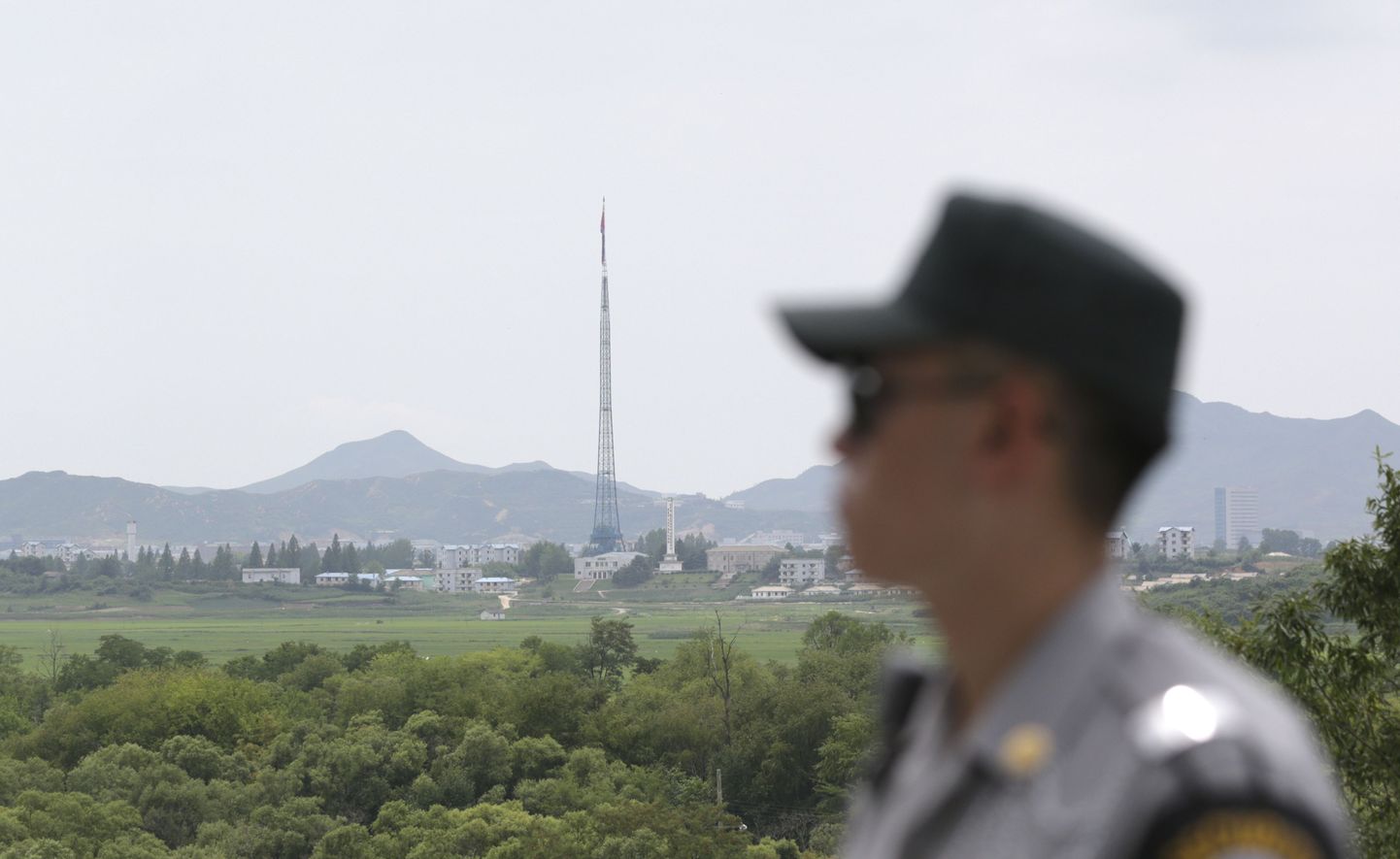 Lõuna-Korea sõdur piiril, taustal paistab torn Põhja-Korea lipuga