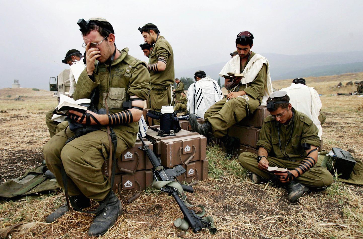 Iisraeli sõdurid relvastusel istudes palvetamas.