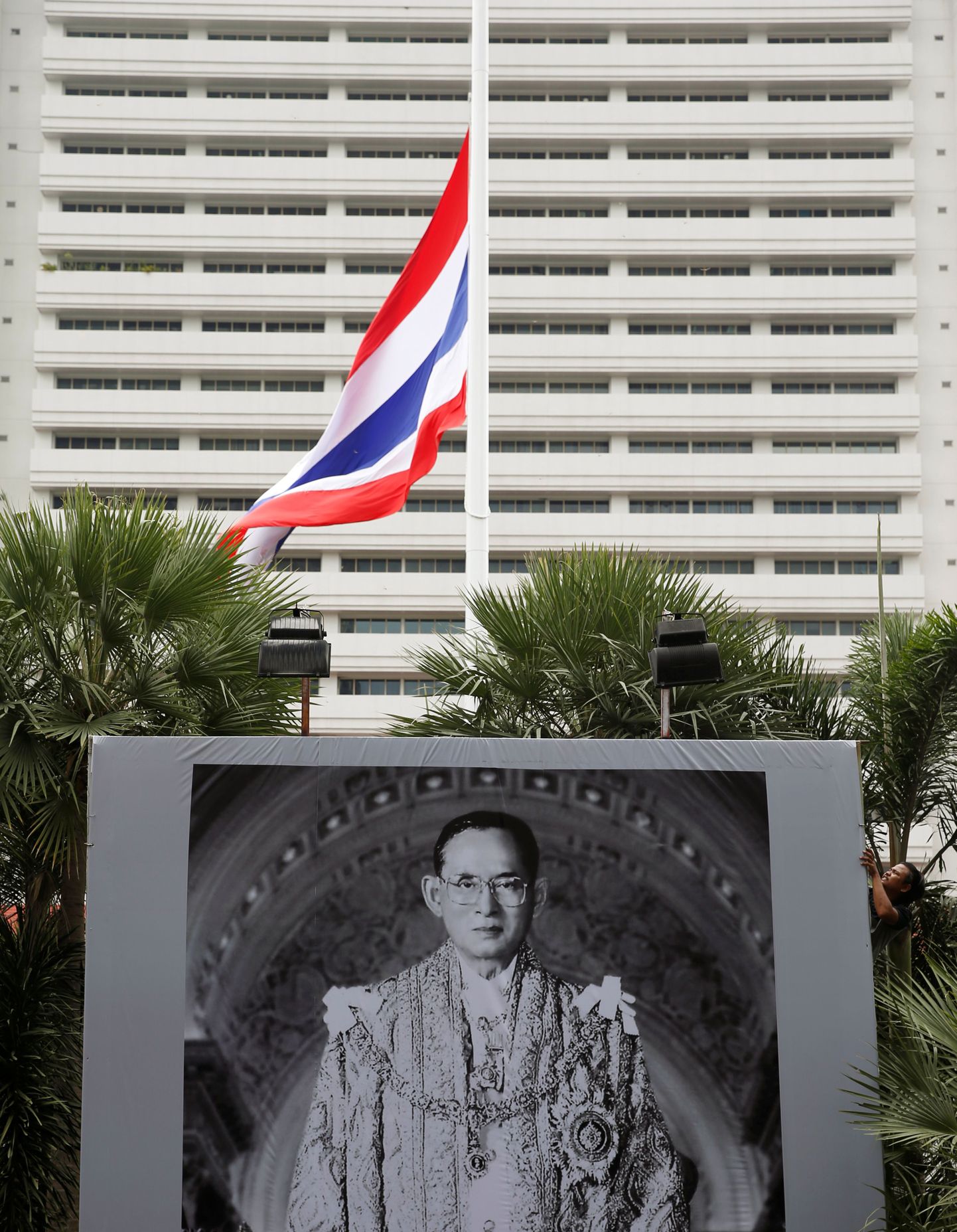 Tai lahkunud kuningaa Bhumibol Adulyadeji portree ja riigilipp politsei peakorteri ees.