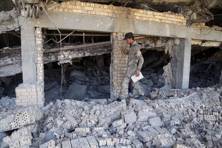 Iraagi sõdur inspekteerimas purustatud hauamonumenti.
