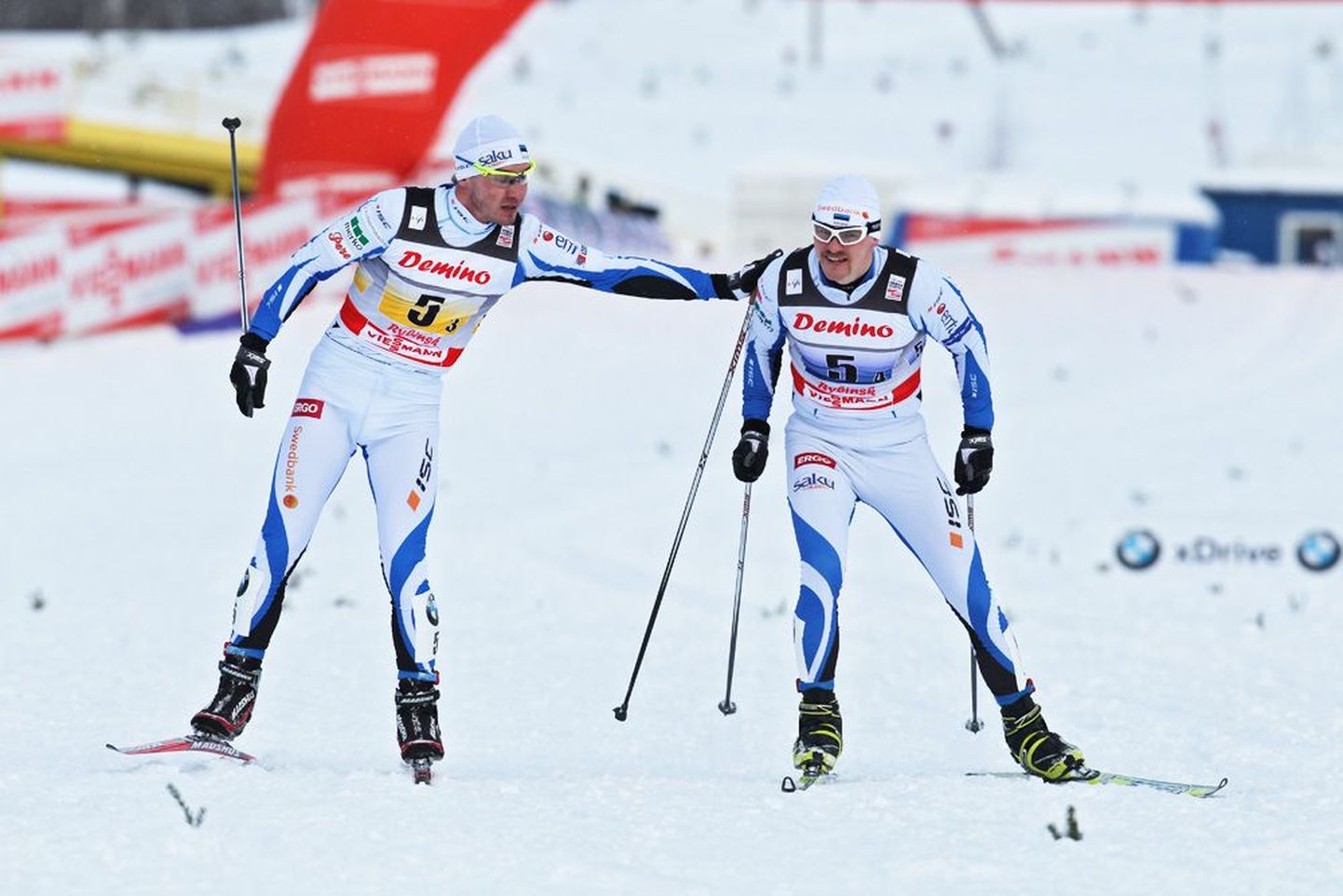 Kaspar Kokk (vasakul) eile Rõbinski MK-etapi 4 x 10 km teatesõidus Anti Saarepuud rajale saatmas. Eesti meeskond sai eelviimase, 9. koha.
