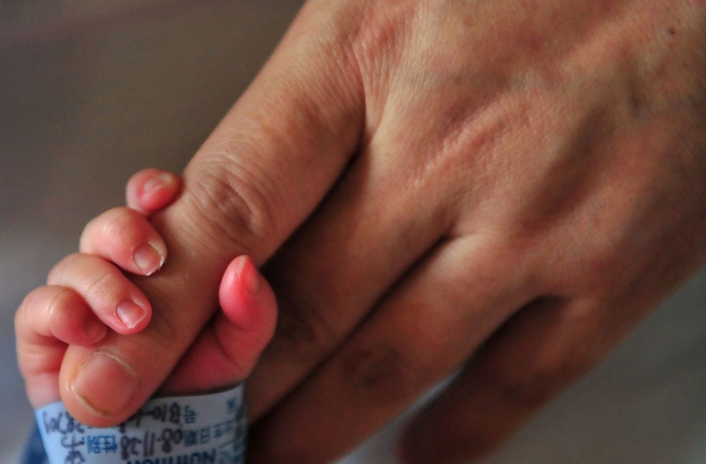 Vastsündinu 1. detsembril 2008. Pekingi haiglas ema sõrmest kinni hoidmas.