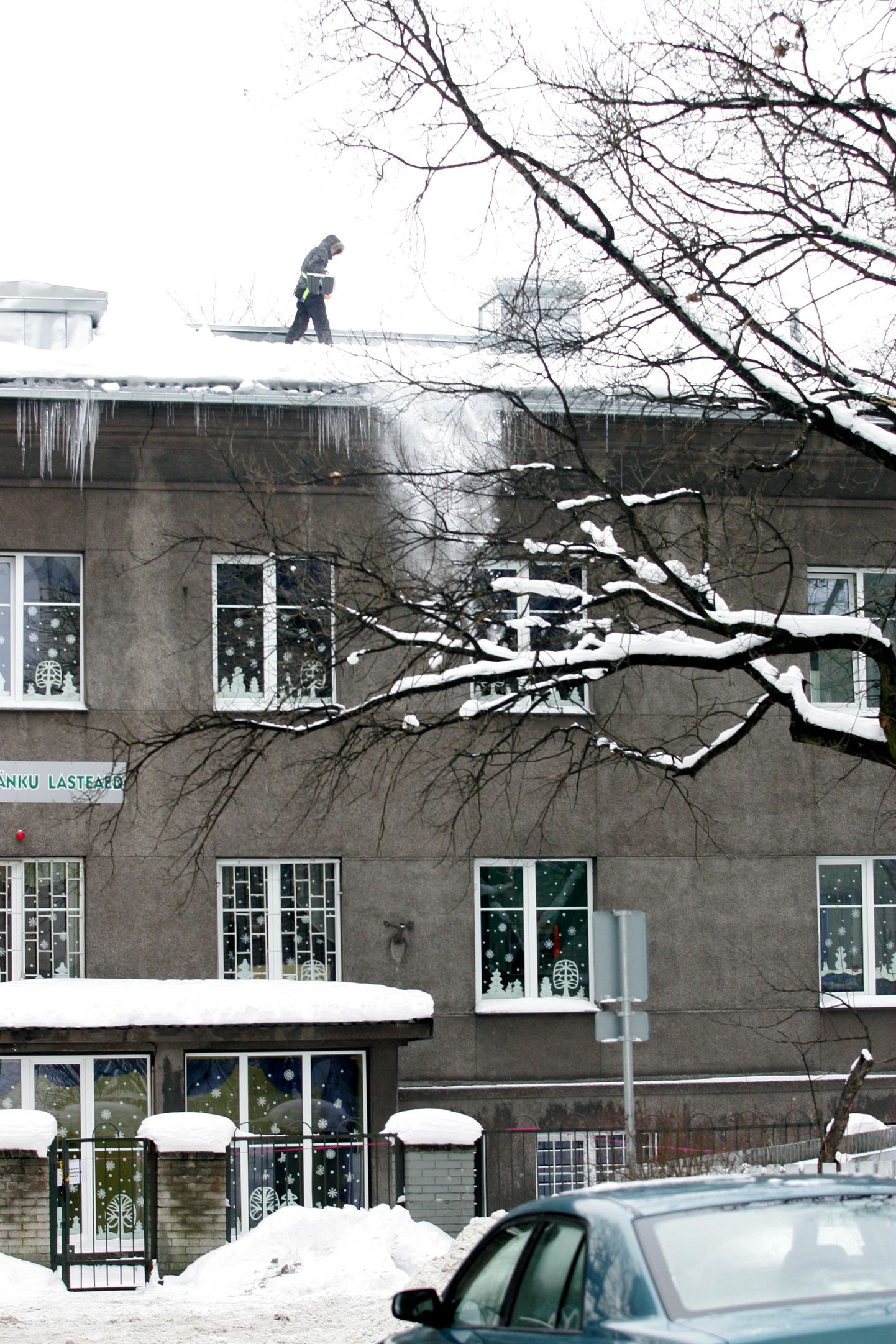 Päikesejänku lasteaed Tallinnas jagas vanematele gripist hoidumise soovitusi. Pildil lume lükkamine lasteaia katuselt.