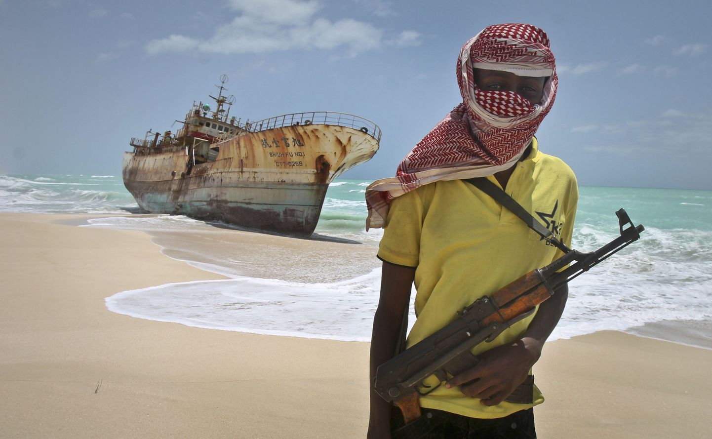 Somaalia piraat Hassan poseerib Taiwani kalalaeva kõrval, mille meeskonna vabaks laskmise eest maksti kurjategijatele kopsakas lunaraha.