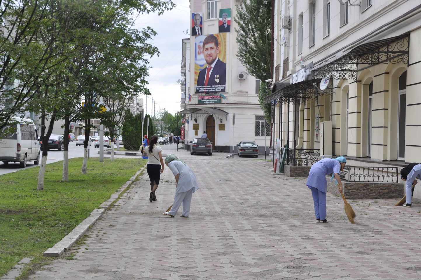 Порядок в доме! Под охраной весящего на стене управы одной из частей Грозного портрета Рамзана Кадырова, работники поликлиники подметают улицу.