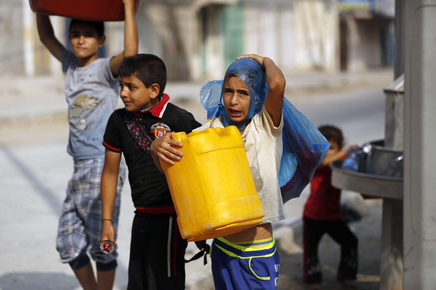 Väikesed poisid laastatud Gaza linnas viivad avalikust veevõtukohast koju värsket joogivett.
