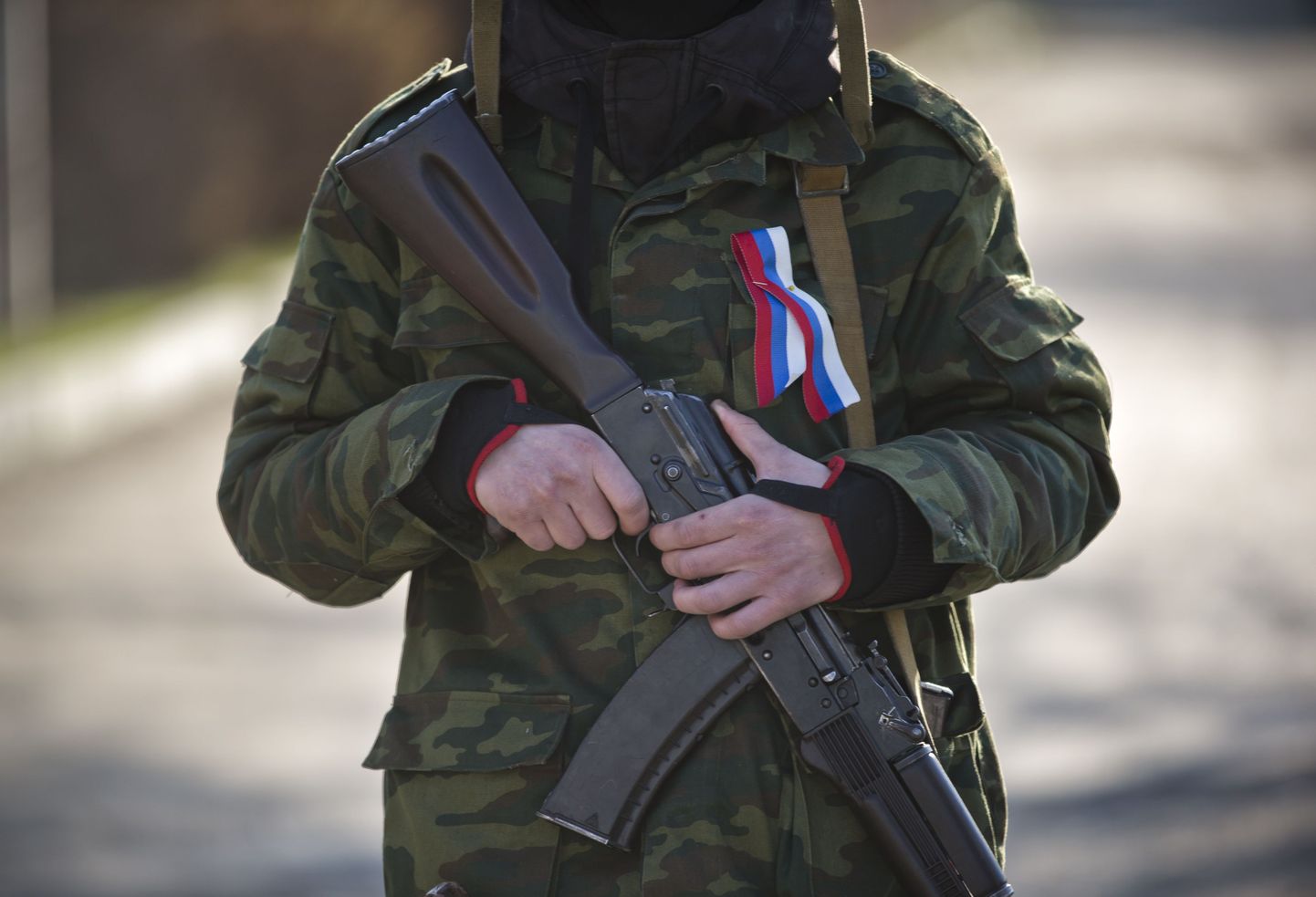 Maskiga relvastatud mees, kes kannab rinnas Vene trikoloori, Simferopolis (Krimmi autonoomne vabariik).