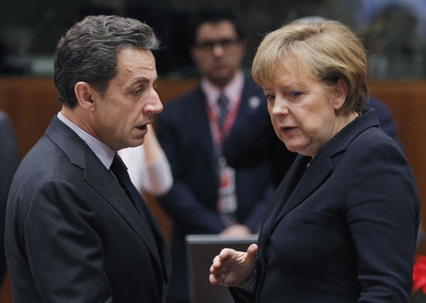 Саркози и Меркель общаются во время встречи в Брюсселе.