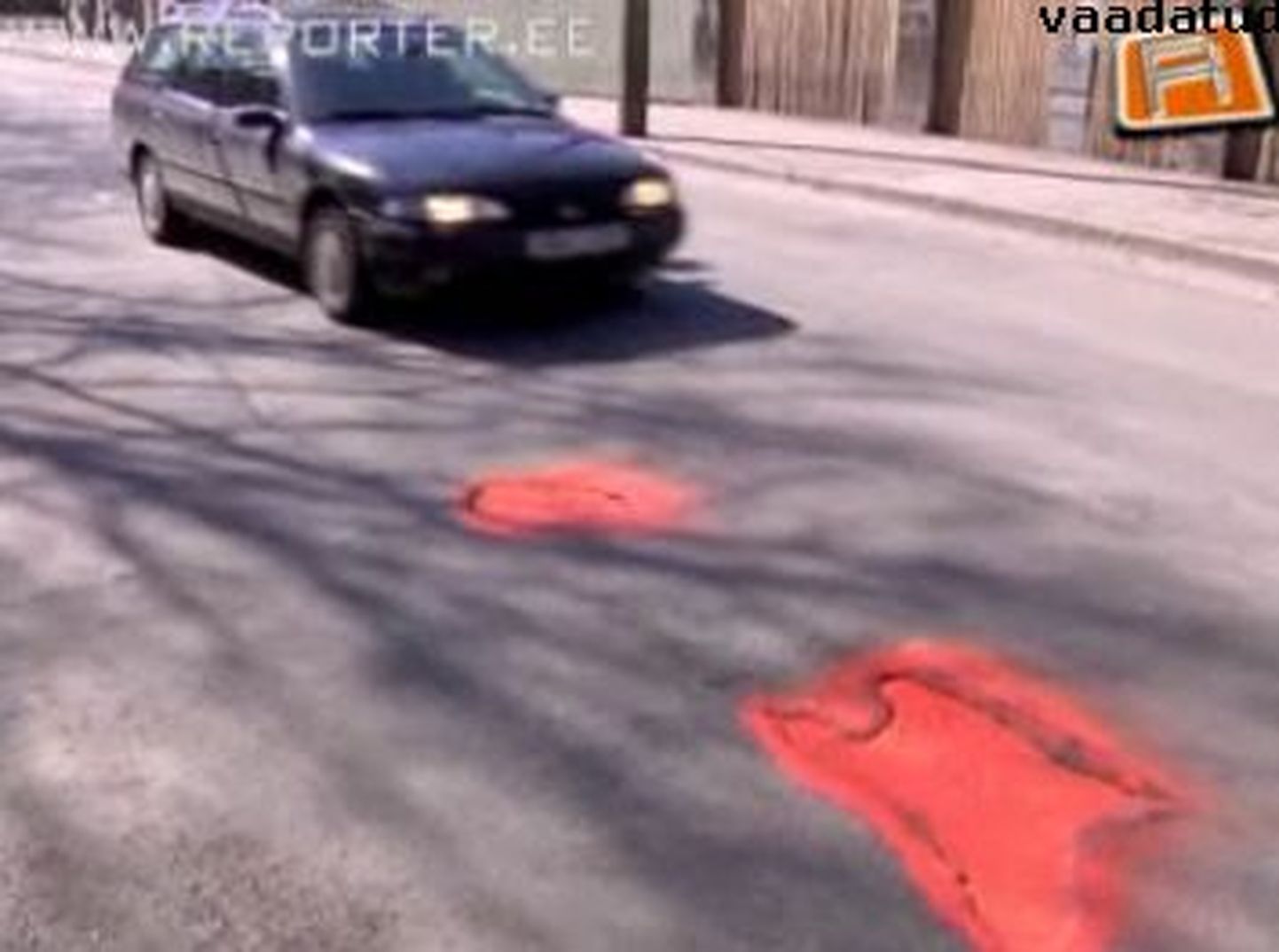 Выбоины на дороге обведены красной краской.