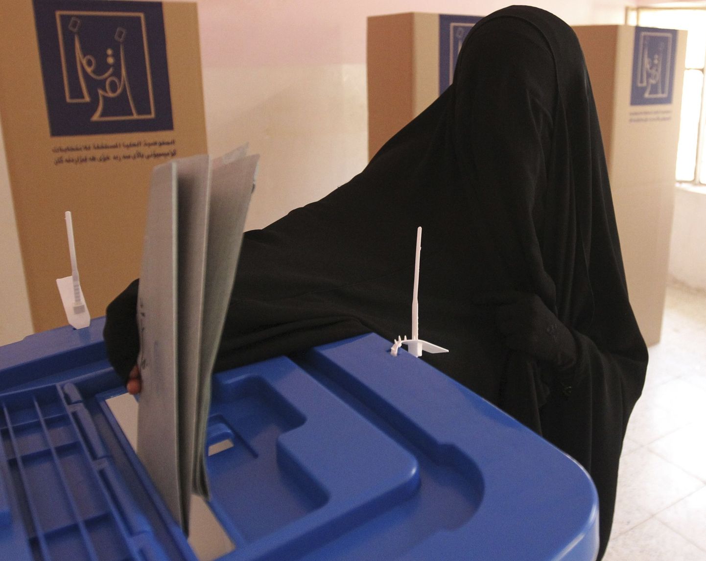 Иракская женщина голосует на избирательном участке в Багдаде.