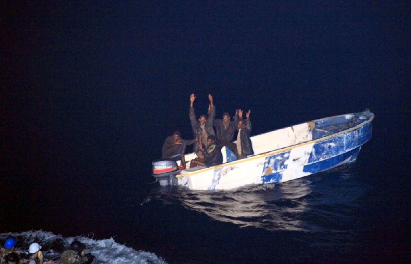 Grupp Somaalia piraate on allaandmise märgiks tõstnud käed üles.