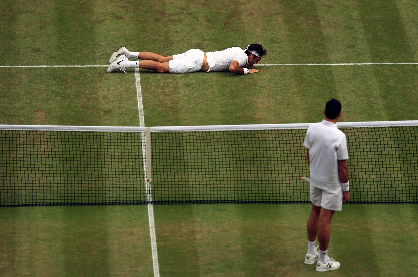 Roger Federer (pikali) pidi Milos Raonicile alla vanduma.