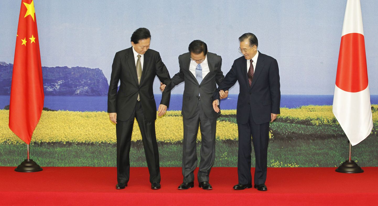 Lõuna-Korea president Lee Myung-bak (keskel), koos Jaapani peaministri Yukio Hatoyama (vasakul) ja Hiina kollegi Wen Jiabaoga kummardavad rahvale tänasel kohtumisel Lõuna-Koreas.