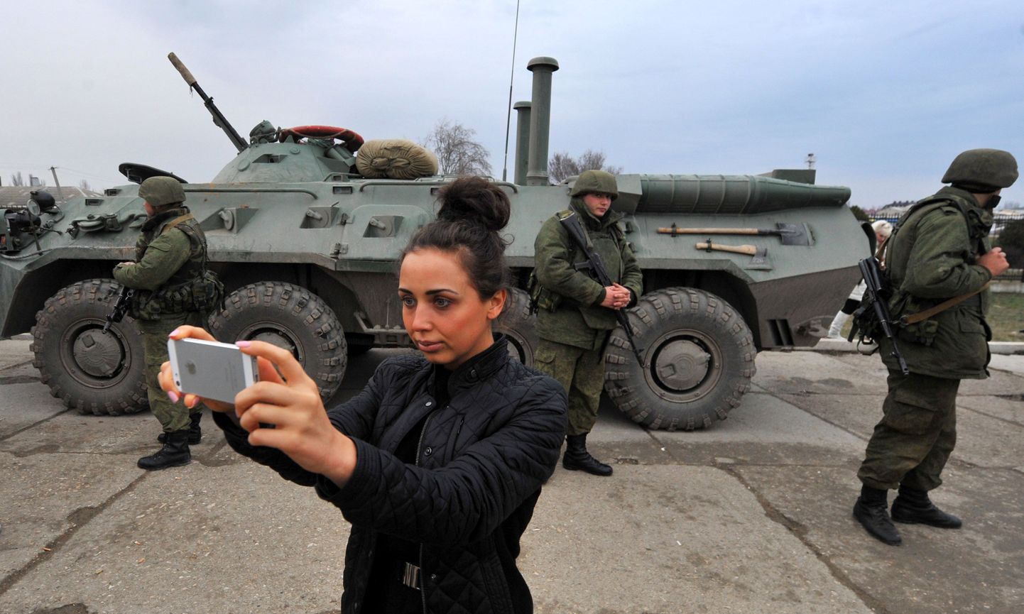 Naine teeb endast pilti relvastatud sõdurite ja soomuki juures Feodossija sadamas Krimmi poolsaare ida osas.