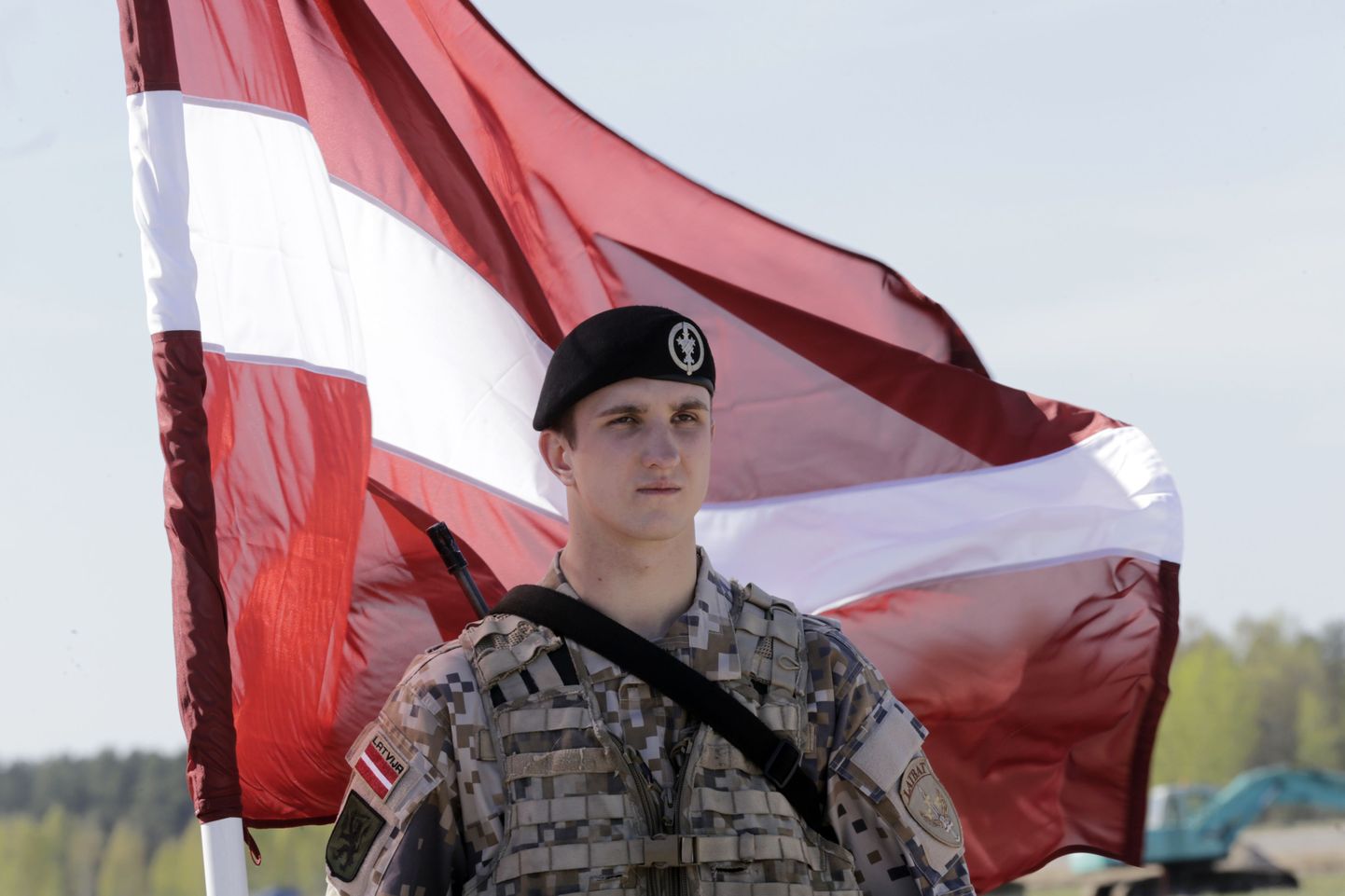 Läti sõdur lipu taustal.