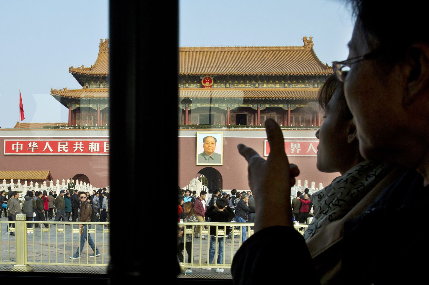 Kaks bussireisijat vaatavad aknast välja Pekingi Taevase Rahu väljaku poole.
