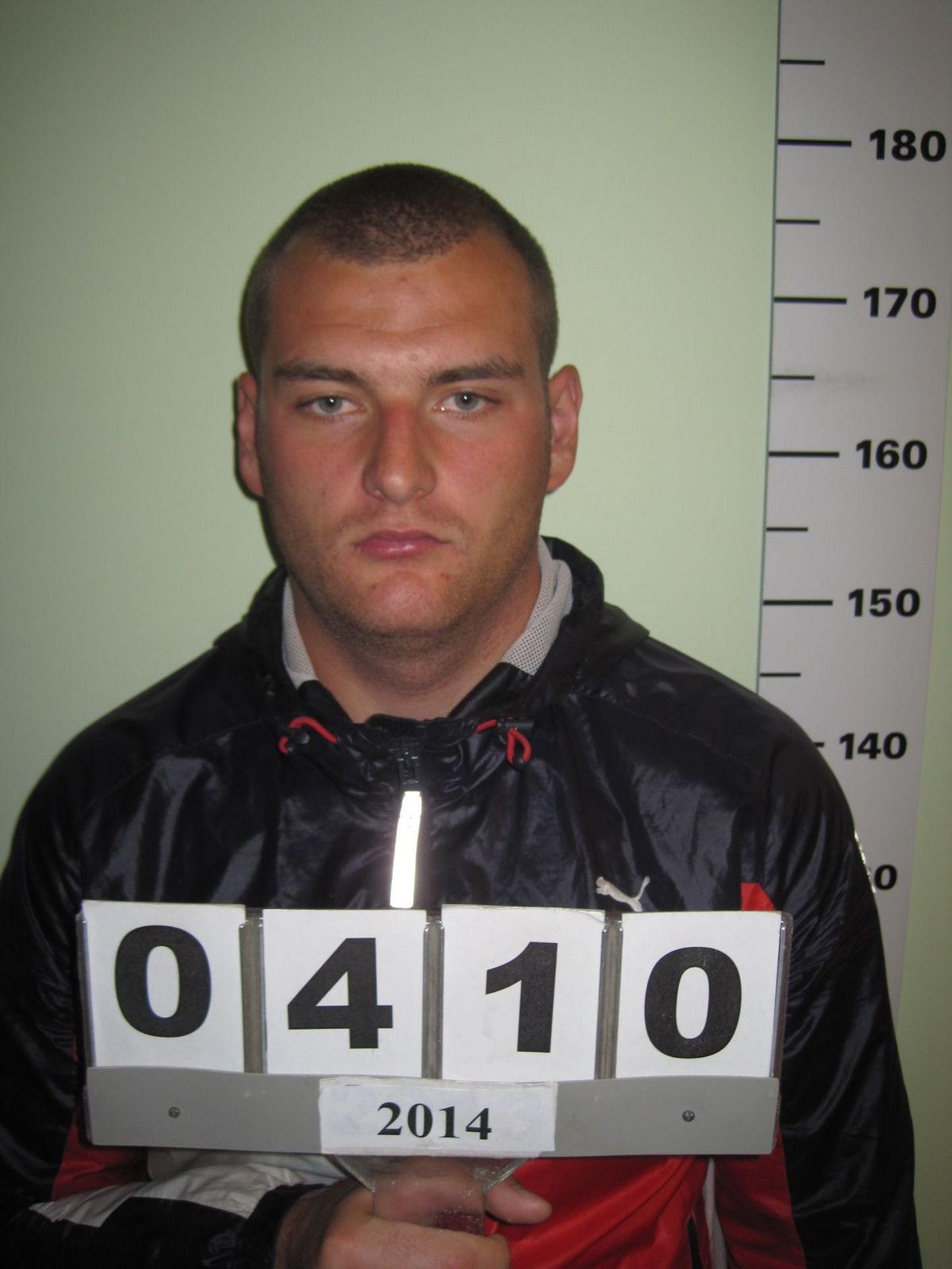 Dmitri Timin poseerimas politseis tehtud isikutuvastamise fotol. Samu sportlikke riideid kandis ta hiljem Rapla arestimajast põgenedes.
