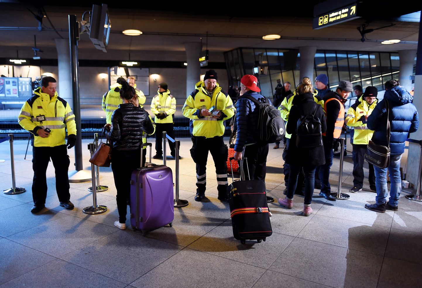 Turvatöötajad teostamas dokumentide kontrolli Kastrupi lennujaama rongijaamas.
