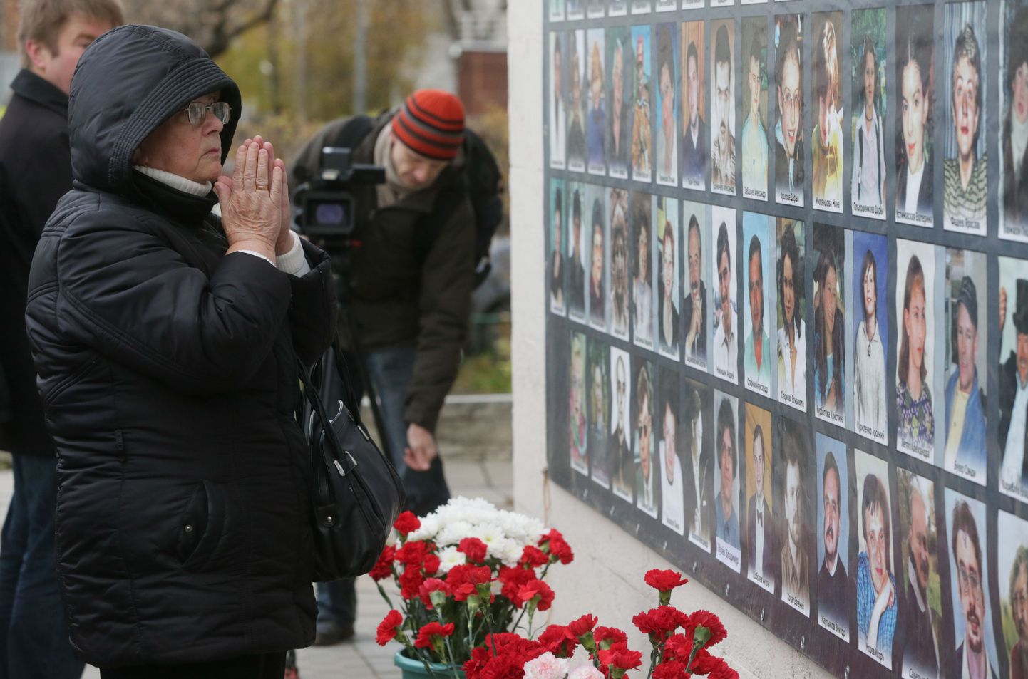 ITAR-TASS: MOSCOW, RUSSIA. OCTOBER 26, 2013. People place candles, flowers and portraits commemorating victims of the 2002 Nord-Ost hostage crisis (theatre terrorist attack, massacre). (Photo ITAR-TASS/ Pavel Smertin)