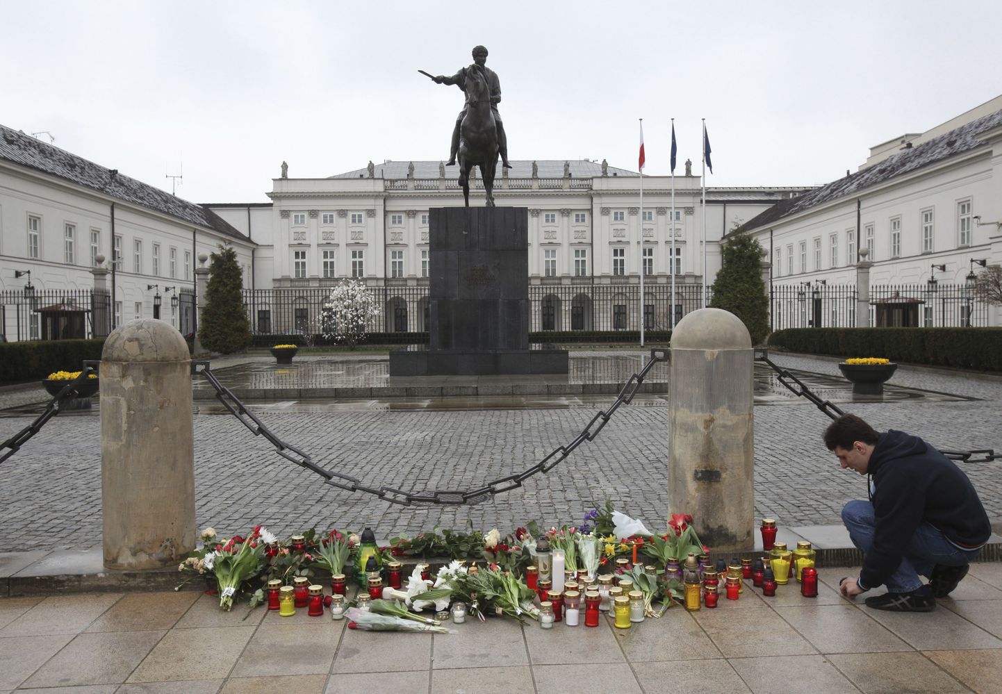 Поляки приносят цветы к президентскому дворцу в Варшаве.