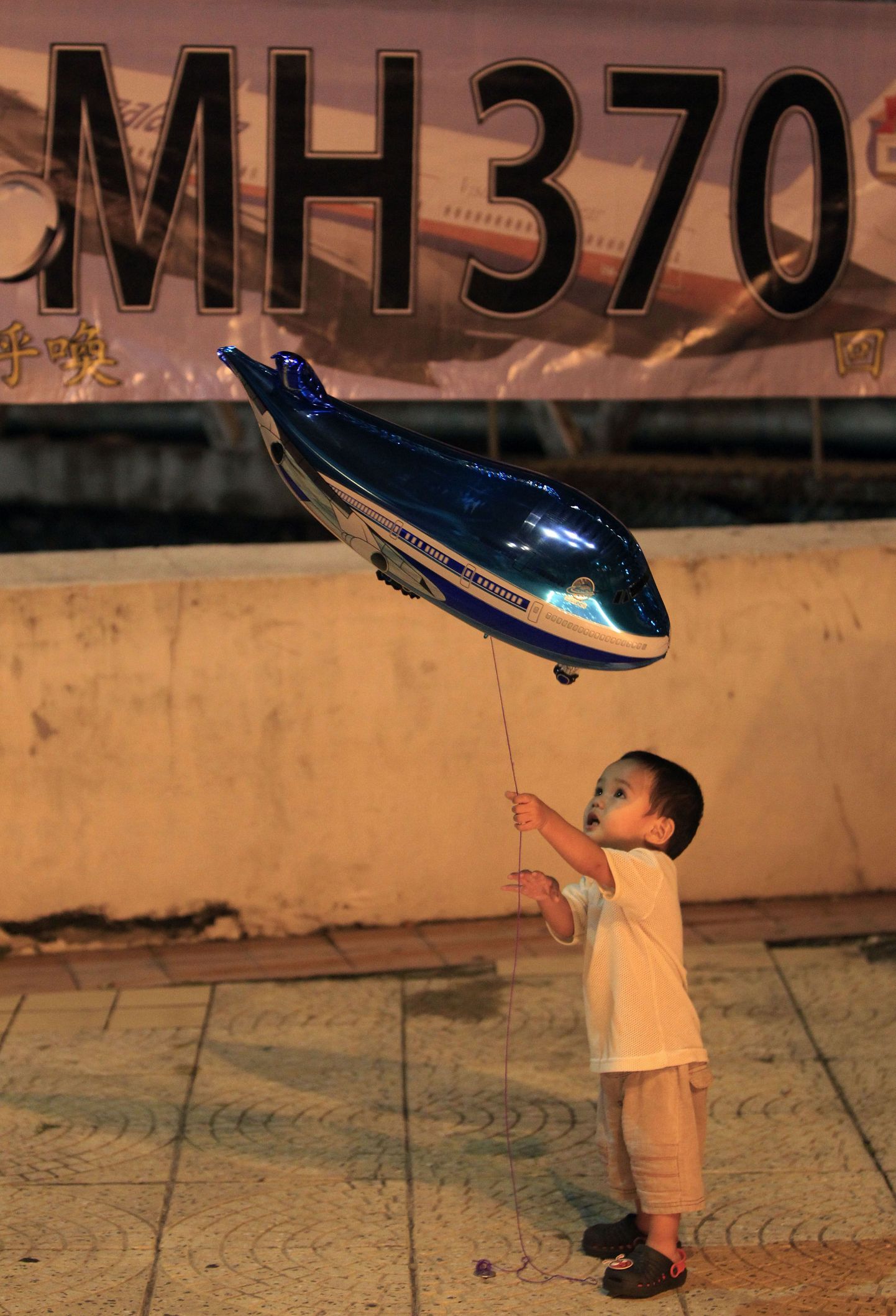 CNN:Malaisia kadunud lennuk võis meelega vältida Indoneesia õhuruumi. Pildil poiss mängimas lennu MH370 mälestusüritusel lennuki kujulise õhupalliga