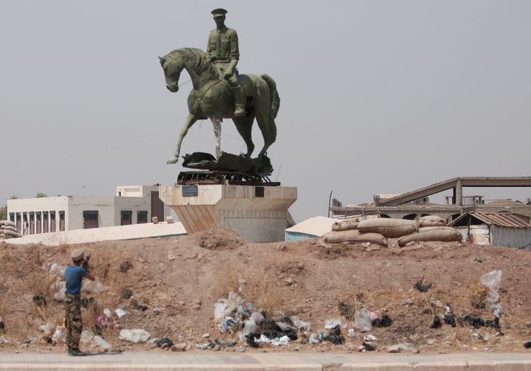 Kurdi võitelja tulistab Bassel al-Assadile pühendatud monumendi pihta. / Scanpix