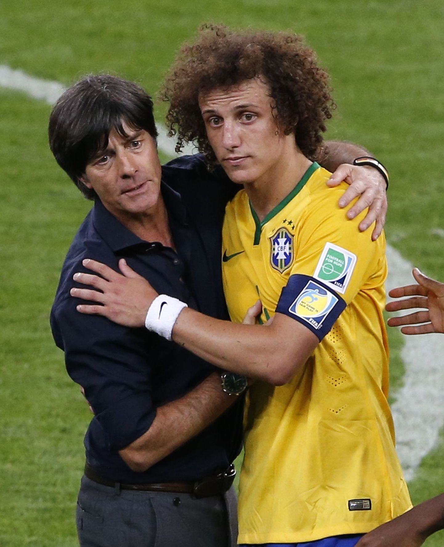 Главный тренер сборной Германии Йоахим Лев утешает защитника сборной Бразилии Давида Луиса.