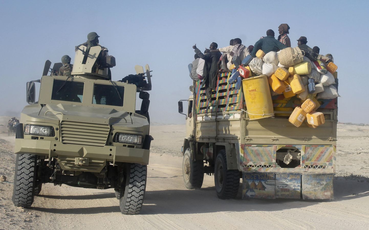 Somaalia tsiviilelanikud lahkuvad lahingute piirkonnast, möödudes teel Aafrika Liidu sõduritest.