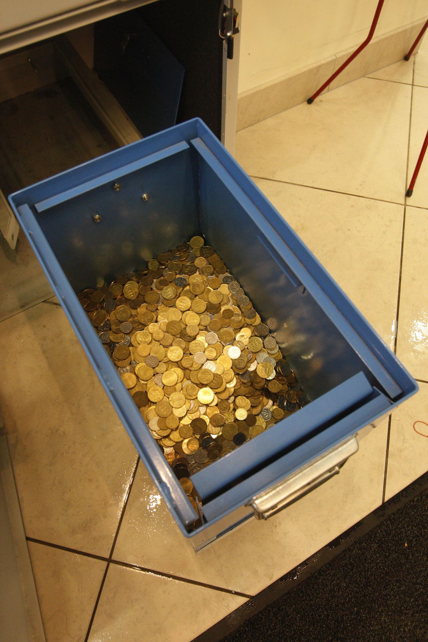 Монеты в ящике аппарата для подсчета мелочи.